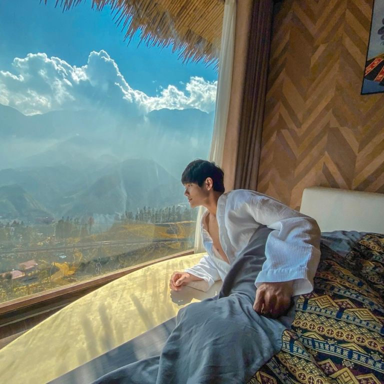 Phòng nghỉ tại homestay có view nhìn ra núi thông qua cửa kính lớn, cho phép bạn ngắm nhìn vẻ đẹp hùng vĩ của Sapa.
